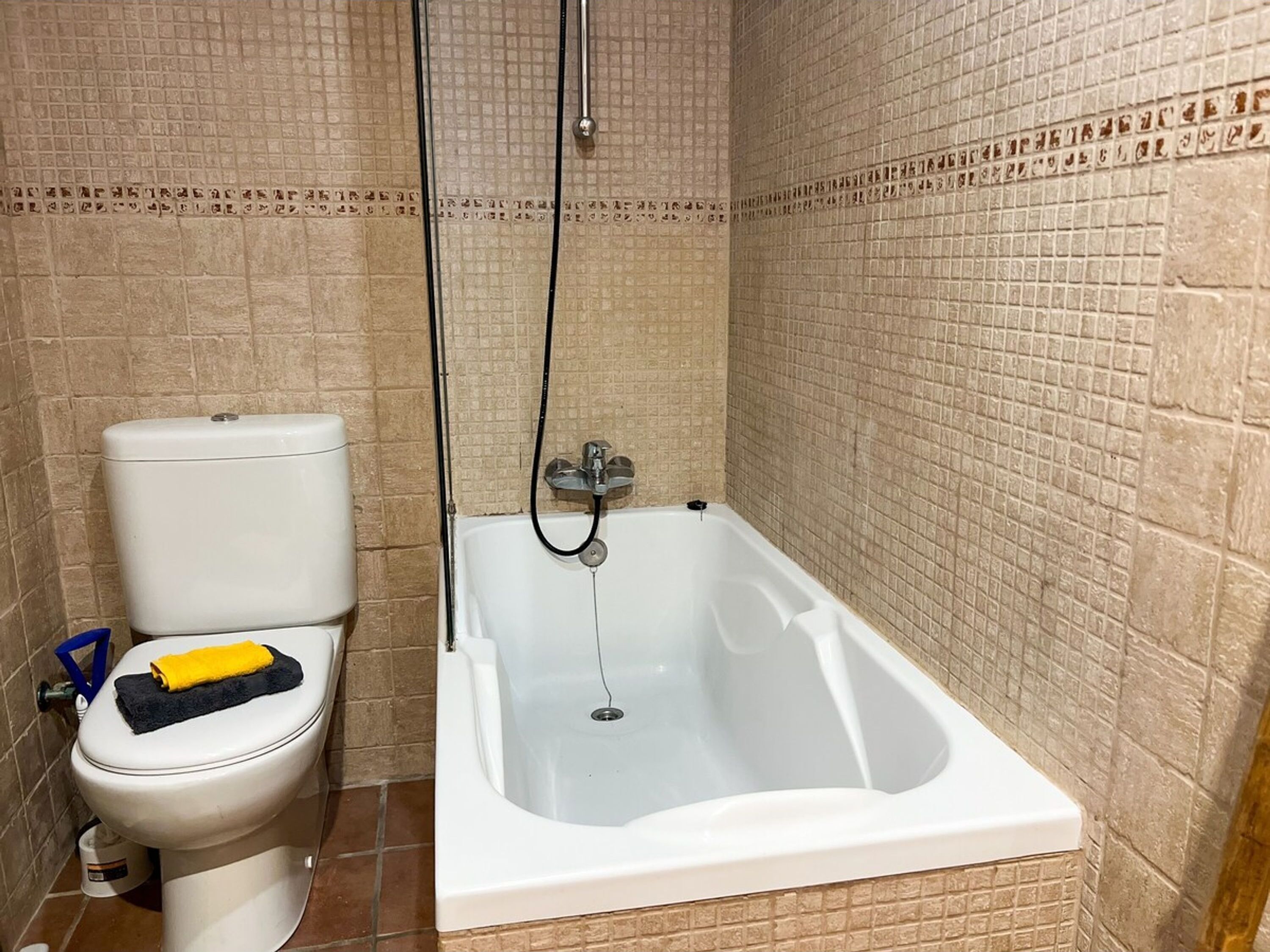 A bathroom with a toilet and a bathtub.