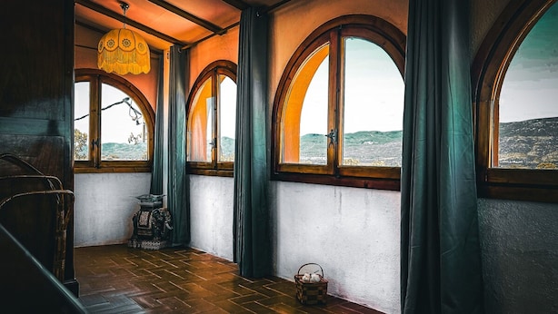 A room with arched windows, a wooden floor, and a hanging light fixture. - Unik Vacation La Noguera Rural Valls (Valls)