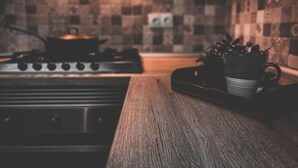 A kitchen with a stove, a tray with a mug, and a tiled backsplash. - Unik Vacation La Noguera Rural Valls (Valls)
