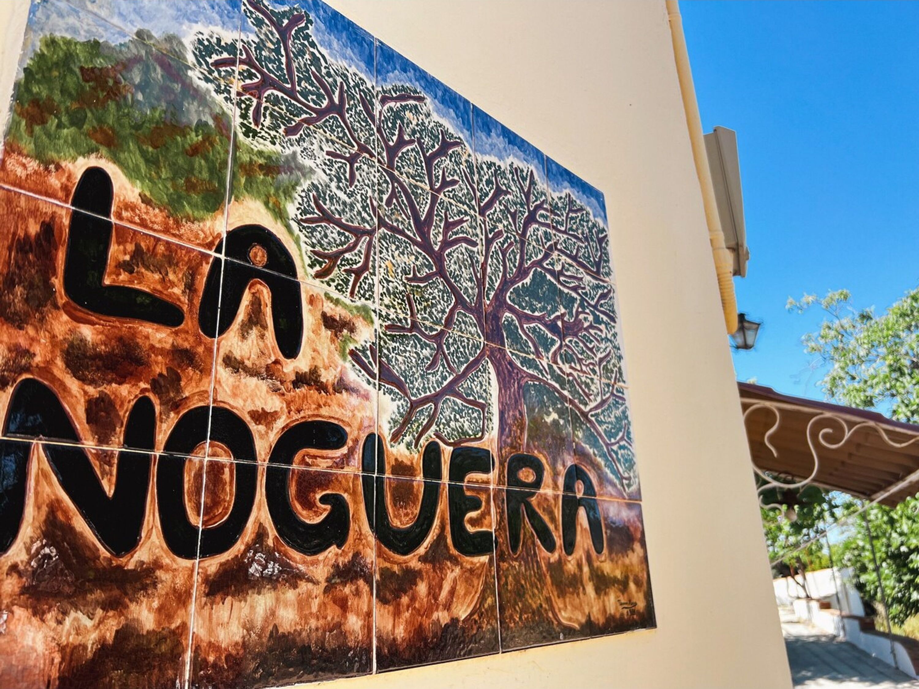 Ein Kachelmosaik mit einem Baum und dem Text "LA VOGUERRA".