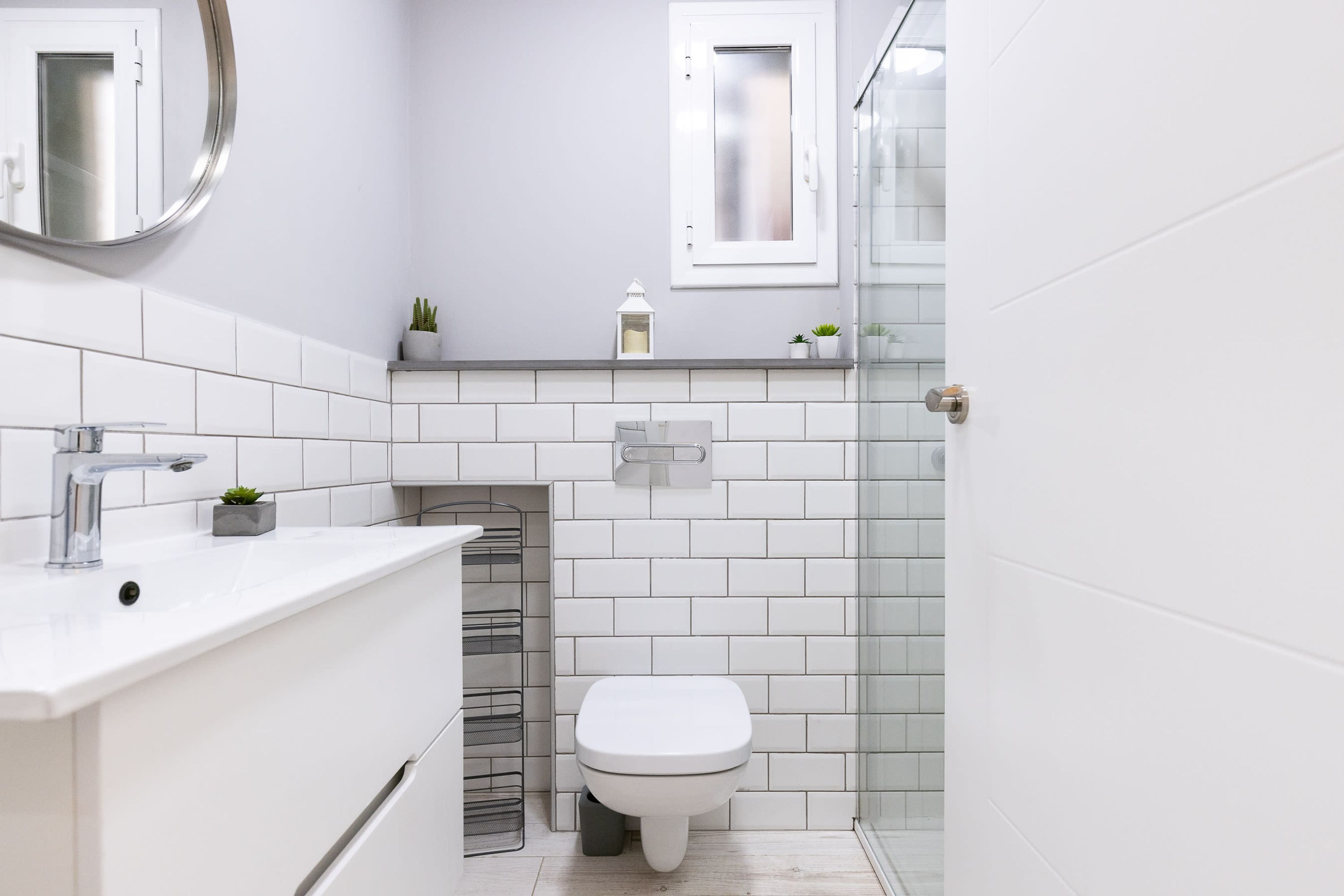 Un baño moderno con lavamanos blanco, inodoro y cabina de ducha de vidrio.