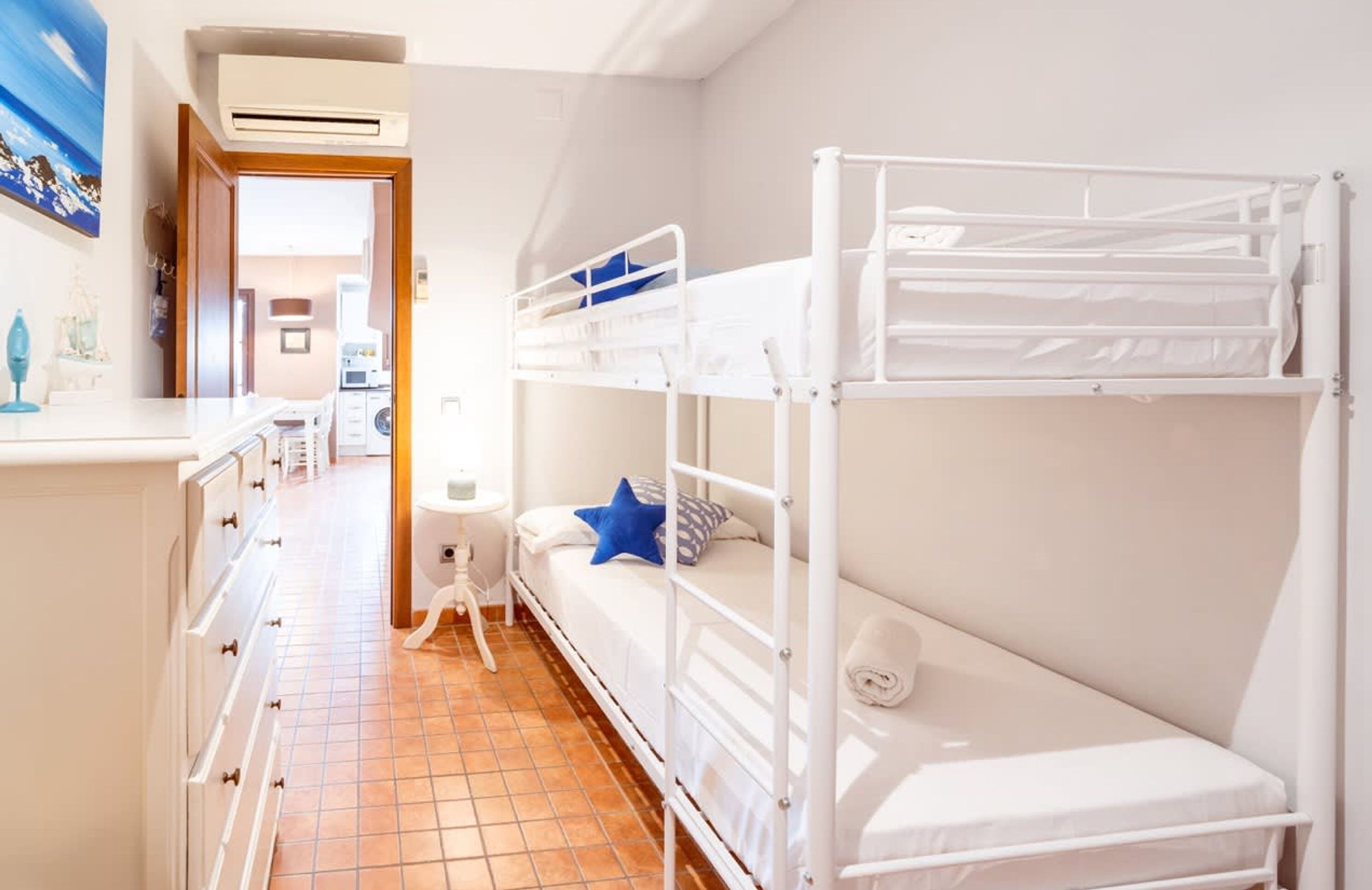 Une chambre d’hôtel avec deux lits superposés, une kitchenette et une salle de bain.