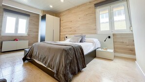 A bedroom with a bed, a wardrobe, a nightstand, and a window. - Unik Vacation Marina (Tarragona)