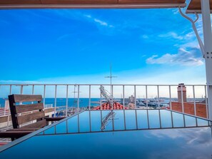 Een balkon met vrij uitzicht op de zee en een jachthaven.