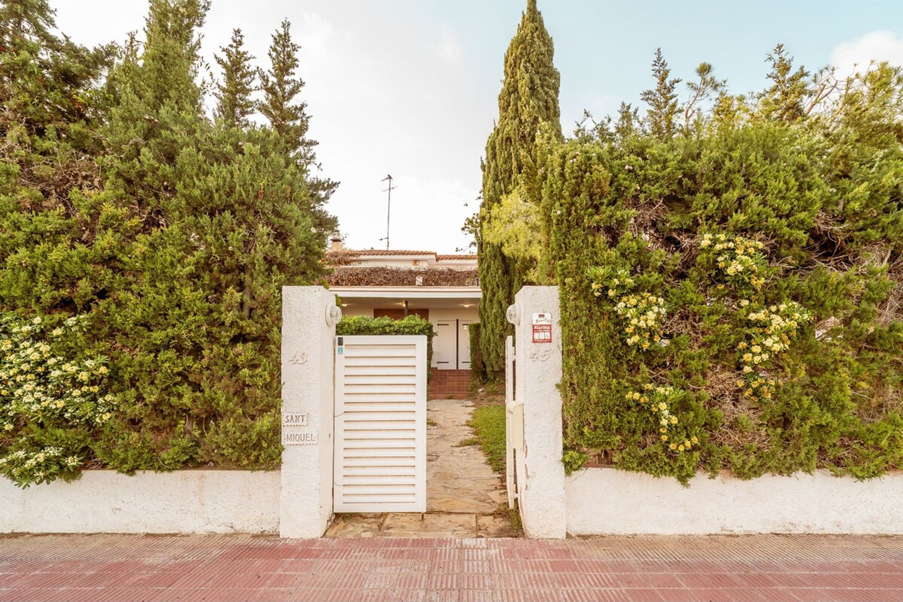 Una entrada con reja y un sendero que lleva a un edificio.