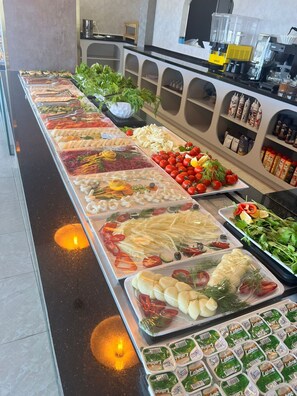 A buffet with various food items, including vegetables, cheeses, and packaged goods. - Blue Lake Otel (Beysehir)