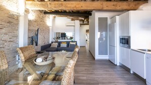 A modern kitchen with white cabinets and a stainless steel refrigerator. - Unik Vacation Panoramic (Tarragona)