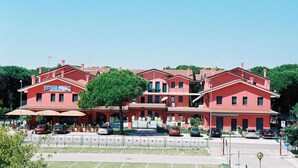 A red building with a sign reading "Ristorante Pizzeria". - Green oasis close to the center (Rosolina Mare)