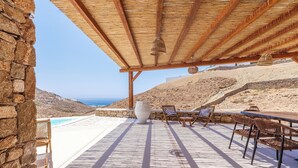 A covered outdoor area with a view of the beach and ocean.
