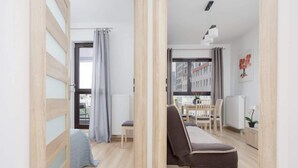 Un apartamento moderno con una cama, zona de comedor y vistas a edificios.