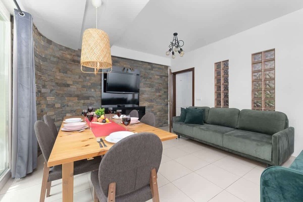 Cozy dining area with a modern green sofa and large windows.