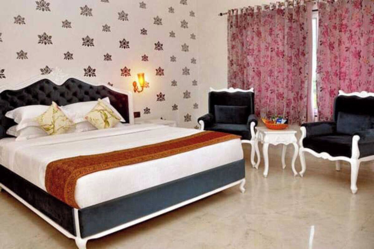 Un dormitorio con una cama grande, dos sillones negros, una mesita y una pared decorativa con diseños de copos de nieve.