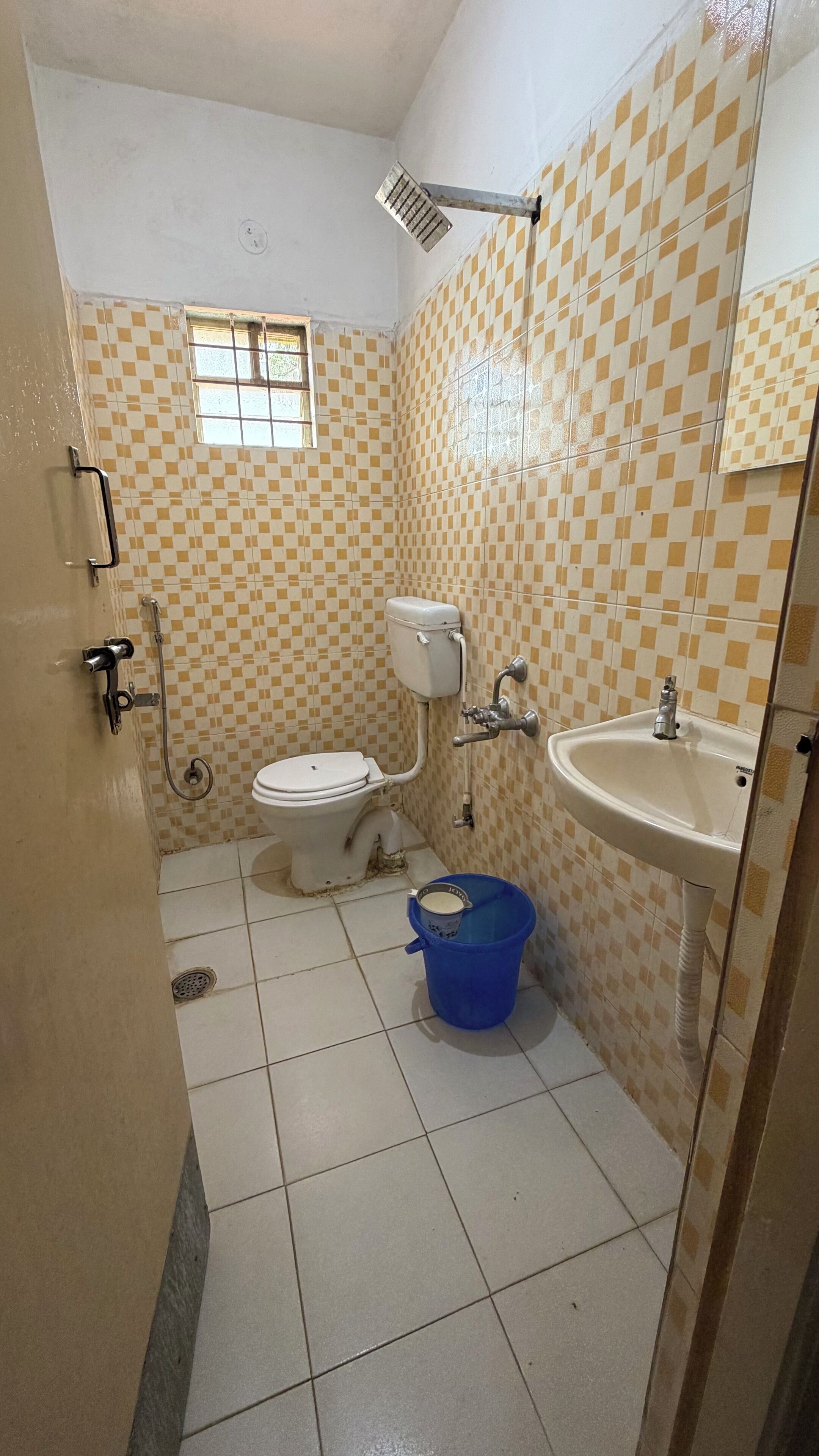 A small bathroom with a toilet, sink, and shower.