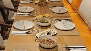 A dining table set for a meal with plates, cutlery, and glasses. - Glitz Bodrum (Bodrum)
