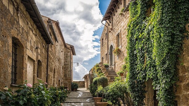 A narrow cobblestone street flanked by stone buildings with arched windows and a staircase leading to an upper level. - Countryside Villa in the Suburbs of Manuuuaus (Manaus)