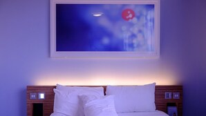 A neatly made bed with white linens, a wooden headboard, and a framed abstract painting above it. - Countryside Villa in the Suburbs of Manuuuaus (Manaus)