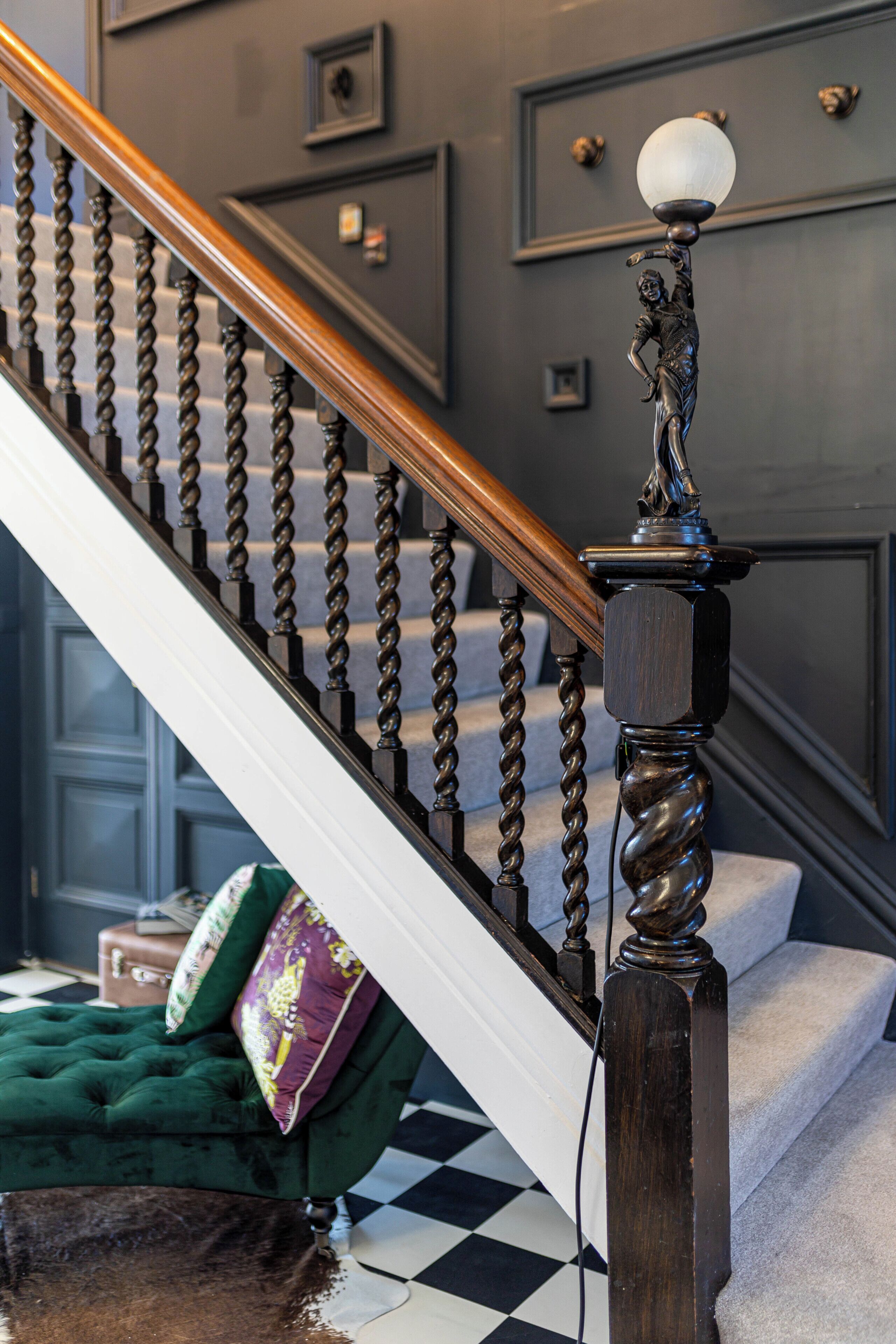 A staircase with a wooden handrail and a decorative balustrade.