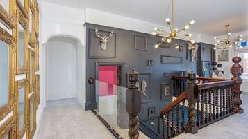 Un magnifique escalier avec des rampes richement décorées et un lustre moderne.