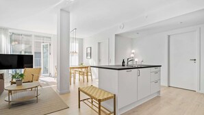 Une cuisine moderne avec des meubles blancs, un plan de travail noir et un évier encastré.