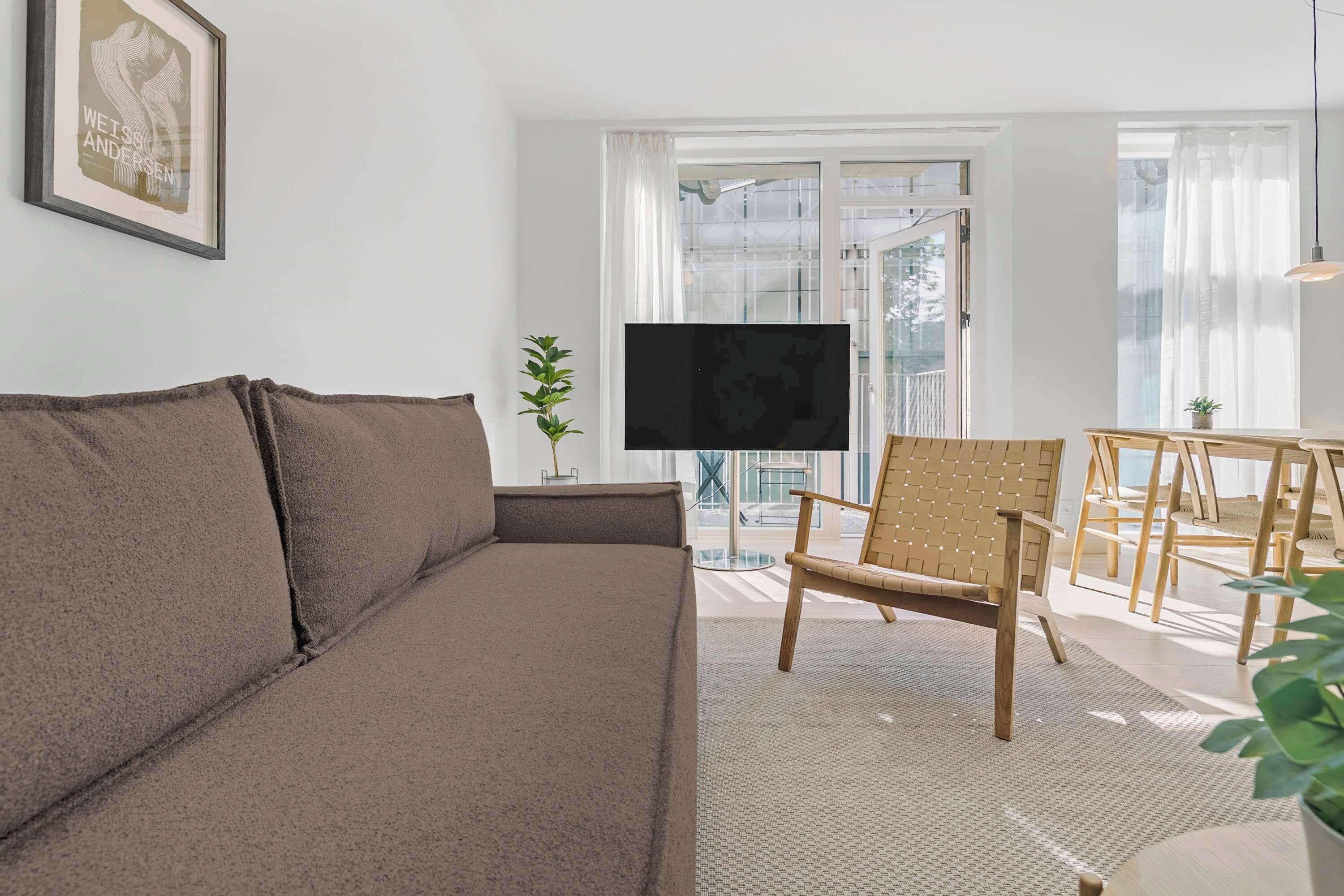 A living room with a sofa, a TV, a chair, and a table.