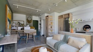 Un salon moderne comprenant un canapé, une table basse et un coin repas avec des chaises et une table.