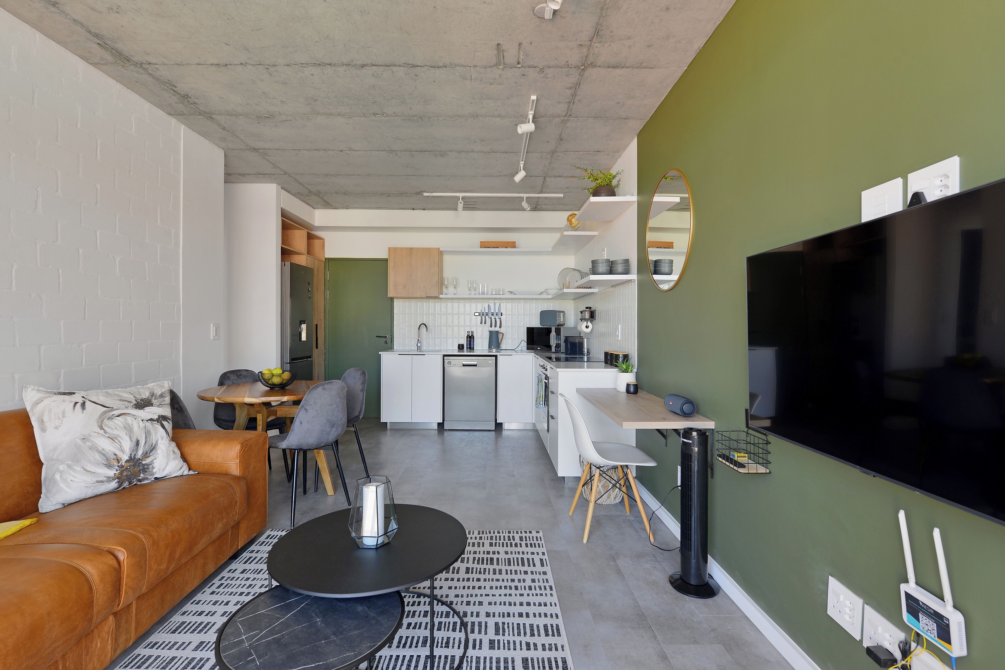A modern apartment with a living room, kitchen, and dining area.