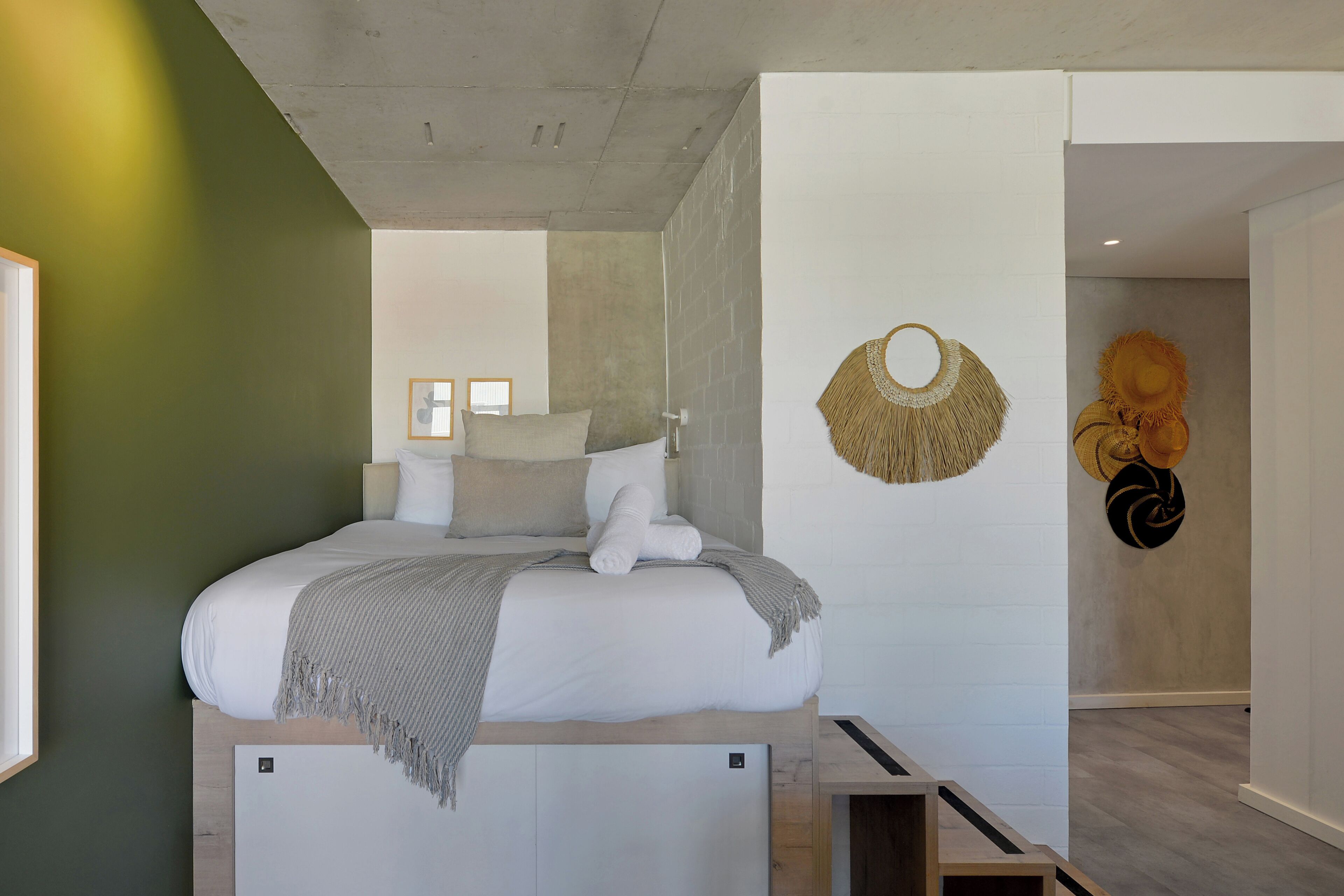 Une chambre moderne avec un lit, une table de chevet et un élément décoratif fixé au mur.