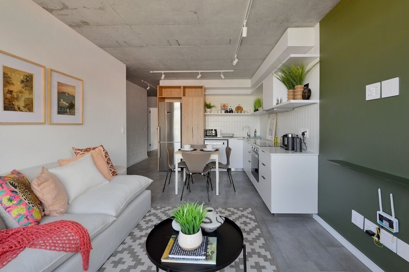 A modern living room with a sofa, coffee table, and a dining area with chairs.