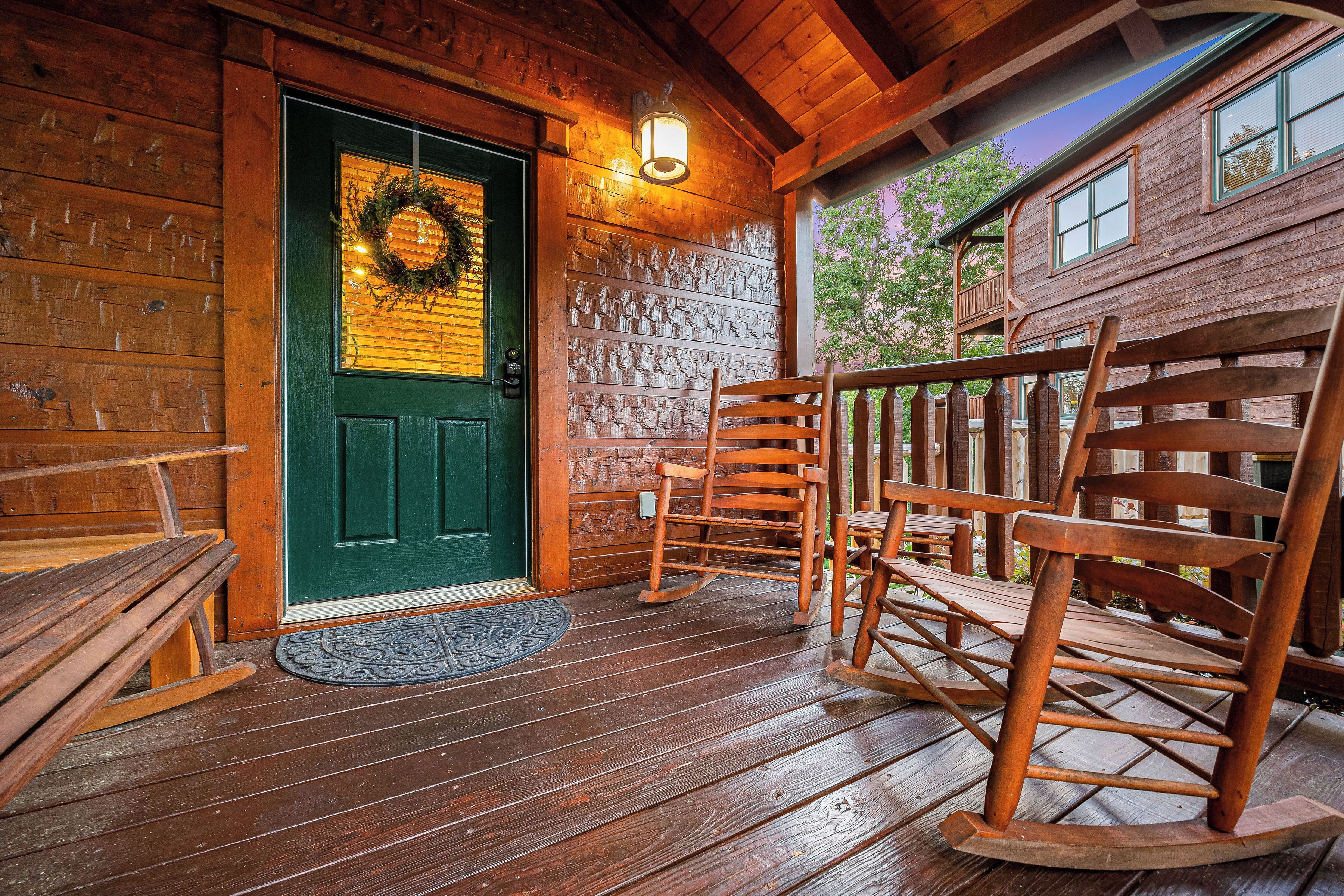 A wooden cabin with a green door, rocking chairs, and a porch.