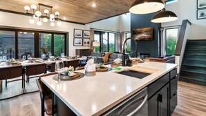 A modern kitchen with a large island, wooden ceiling, and pendant lighting. - Brand New Modern Luxe 6 Bed w/ Arcade Games, Indoor Pool, Great Views! (Sevierville)