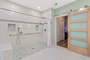 Een douche, een bubbelbad, een bidet, handdoeken