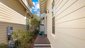 A narrow pathway flanked by buildings with a water heater and outdoor lighting fixture. - Golf Cart+4 Bikes! 5 Min to the Pool, 10 to Beach! 2 King Suites & Custom Bunks! ~ Baha Beach House at WaterSound West on 30A (Santa Rosa Beach)