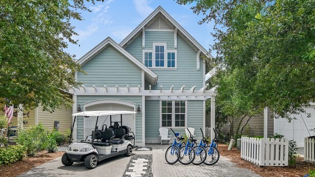 A two-story house with a porch, a golf cart, and bicycles parked in front. - Golf Cart+4 Bikes! 5 Min to the Pool, 10 to Beach! 2 King Suites & Custom Bunks! ~ Baha Beach House at WaterSound West on 30A (Santa Rosa Beach)