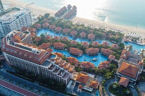 Relax by the central swimming area surrounded by bungalows, with access to the beach.