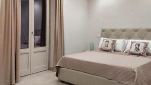 A bedroom with a bed, a wardrobe, and a nightstand. - Masseria Torre Saracena (Favara)