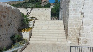 A stone staircase leading up to a building with a view of a hill in the background. - Masseria Torre Saracena (Favara)