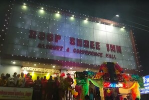 Un hotel con un cartel grande que dice 'BOOP SHREE INN' y 'SALÓN DE CONFERENCIAS Y BANQUETES'.