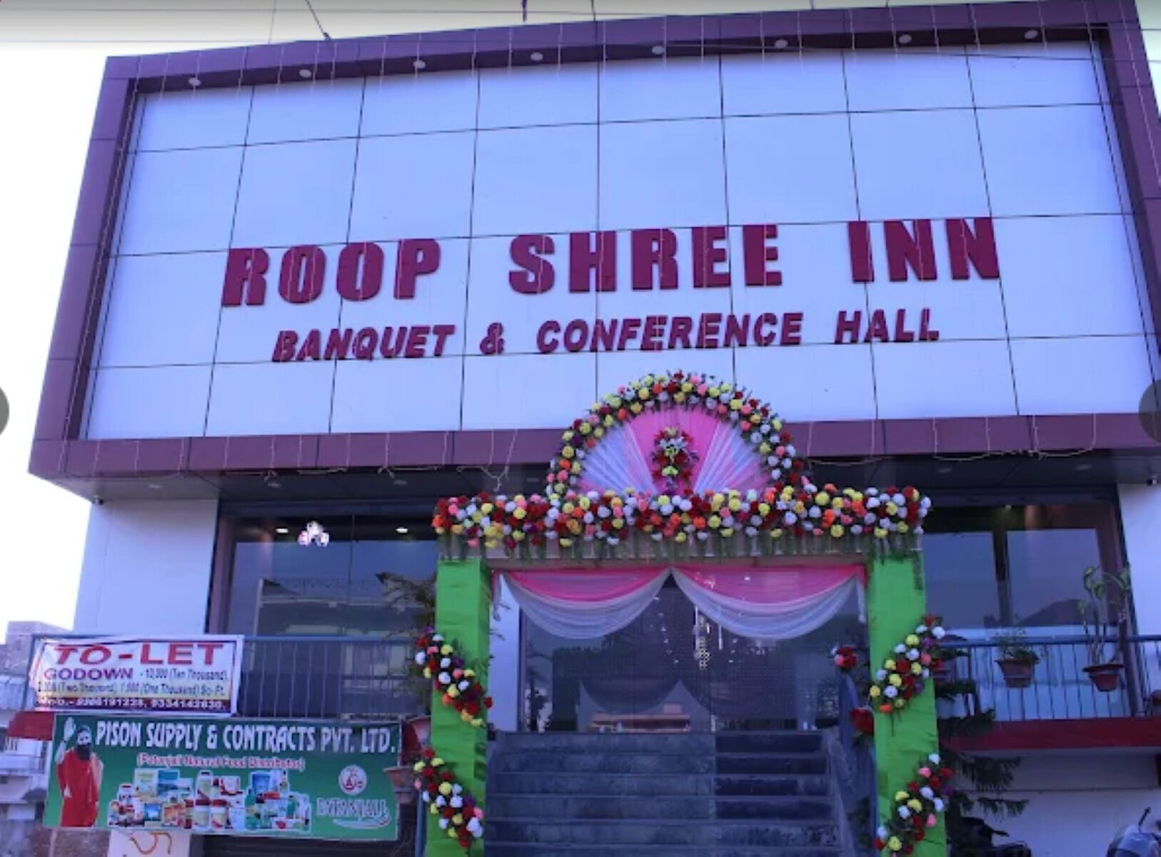 Un bâtiment sur lequel on peut lire l’inscription suivante : « Roop Shree Inn, salle de banquet et de conférence ».