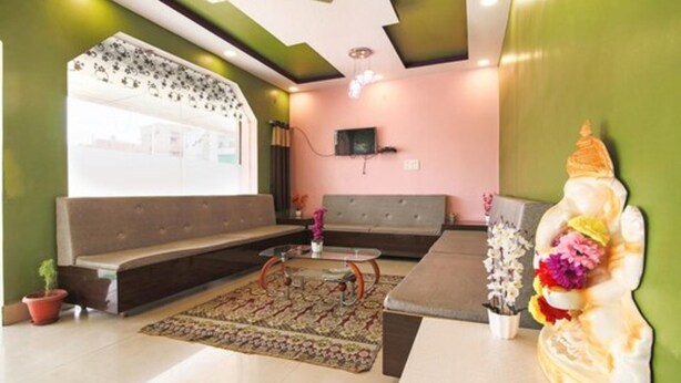A modern living room with a sofa, coffee table, and decorative items. - Hotel Roop Shree Inn By GRB (Patna)