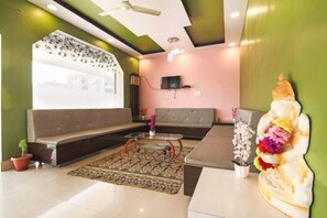 A modern living room with a sofa, coffee table, and decorative items. - Hotel Roop Shree Inn By GRB (Patna)