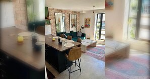 En moderne opholdsstue med spiseplads, en grøn sofa og et sofabord.