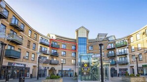 A multi-story building with balconies, a glass entrance, and a clear sky. - 2 Bed City Centre Penthouse with Cathedral Views (Dublin)