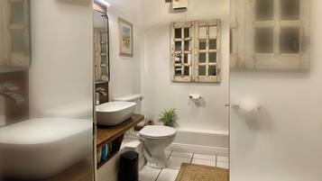 A bathroom with a bathtub, toilet, and sink.