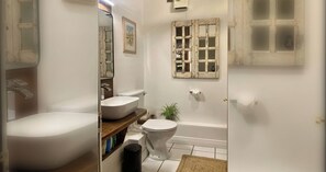 Une salle de bain avec une baignoire, des toilettes et un lavabo.