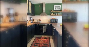 A kitchen with dark cabinets, a microwave, a toaster, and a coffee maker. - 2 Bed City Centre Penthouse with Cathedral Views (Dublin)