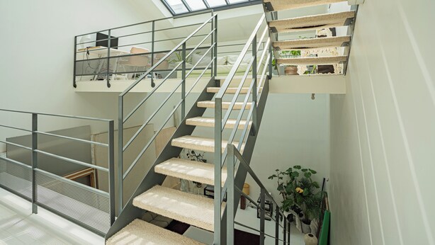 A modern staircase with glass railings and cat trees, leading to a lofted area with a view of the sky. - Stunning 3BD Industrial-style Maisonette—Villette (Paris)