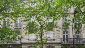 A multi-story building with classical architecture, featuring arched windows and balconies. - Beautiful 1BD Apartment—Porte Dauphine (Paris)