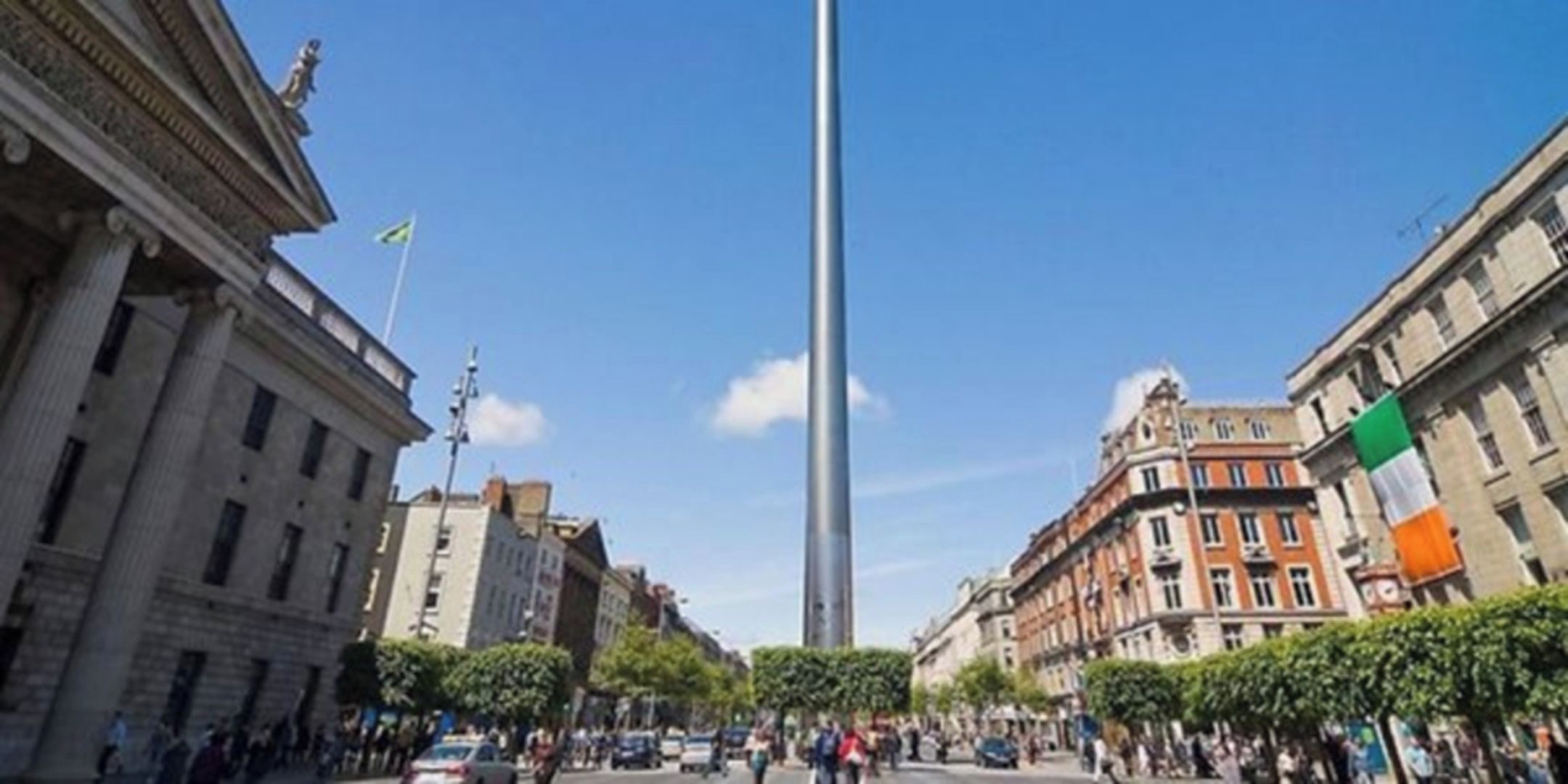 Un monumento alto en una plaza urbana rodeada de edificios históricos.
