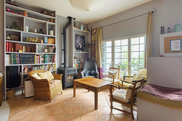 A cozy living room with a fireplace, bookshelves, and comfortable seating. - Artistic Parisian Home for 5 in Charonne (Paris)