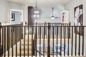 A staircase with a railing, a ceiling fan, and a chandelier. - Backyard Resort,hottub,heated Pool,firepit,uofo 6m (Eugene)